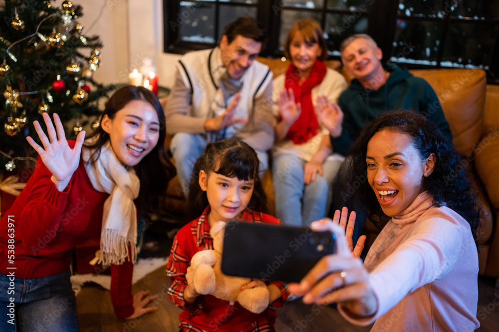 Multi-ethnic big family use mobile phone video call online to relative