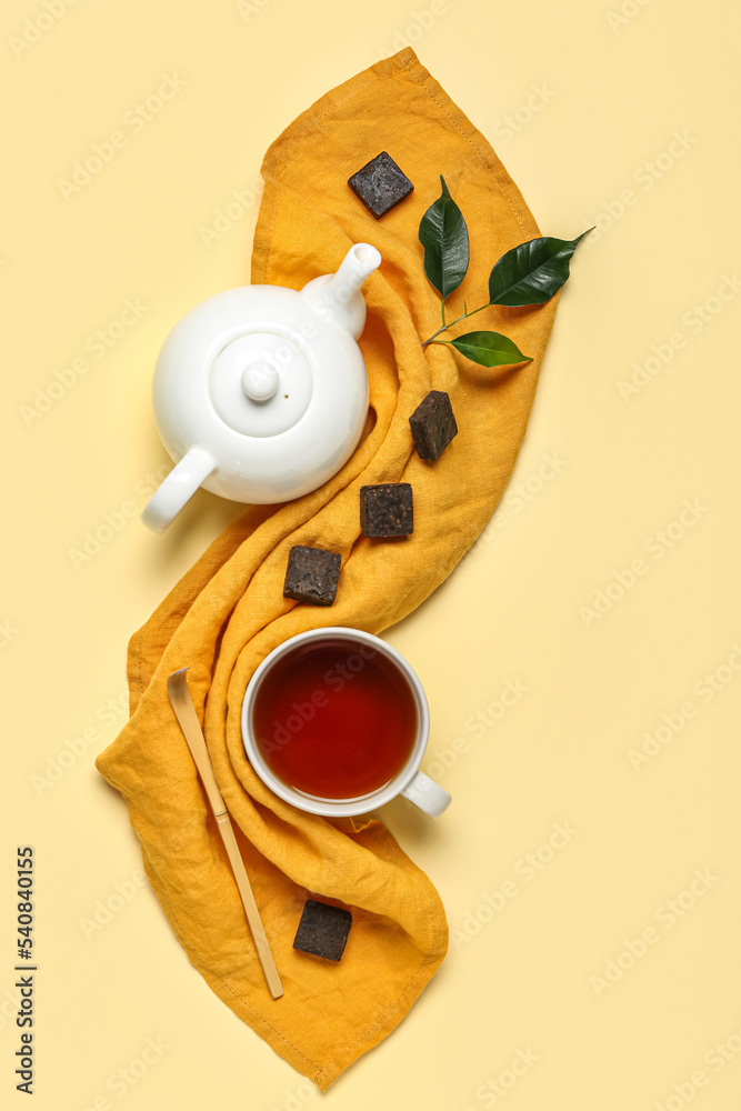 米色背景的干压普洱茶、杯子和茶壶餐巾