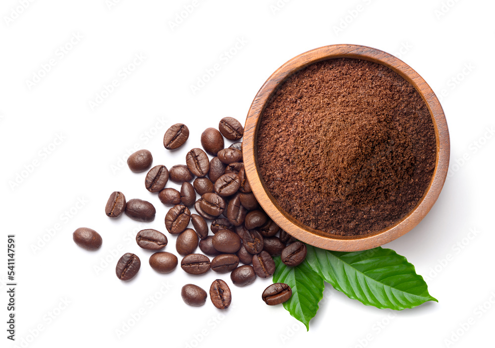 在白色背景上，用咖啡豆和真正的咖啡叶铺成的咖啡地面。