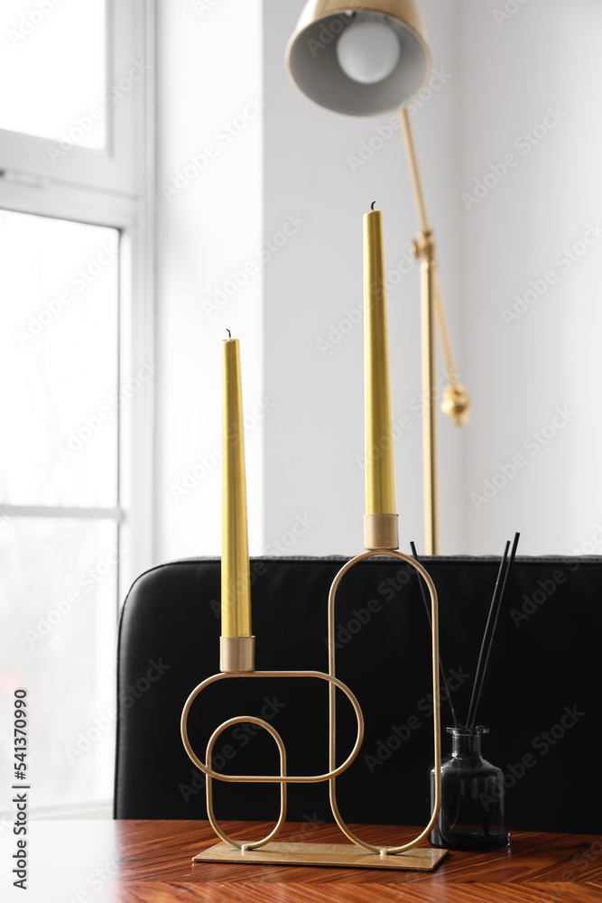 木制桌子上的带蜡烛和芦苇扩散器的时尚支架