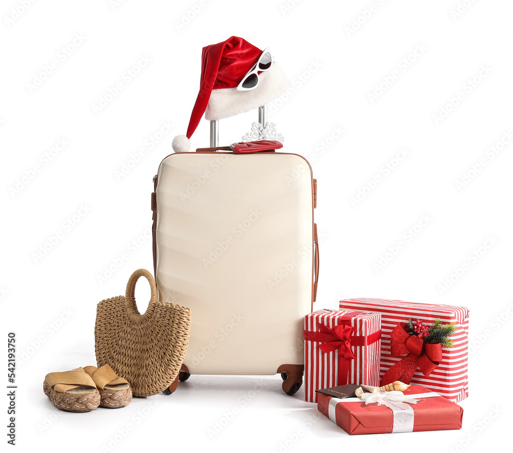 白色背景圣诞帽、圣诞礼物和旅行配饰的手提箱