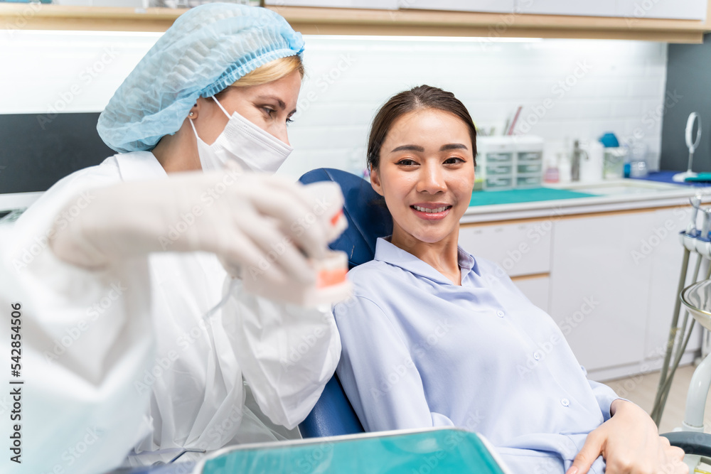 牙医在牙科诊所向患者解释口腔护理刷牙。