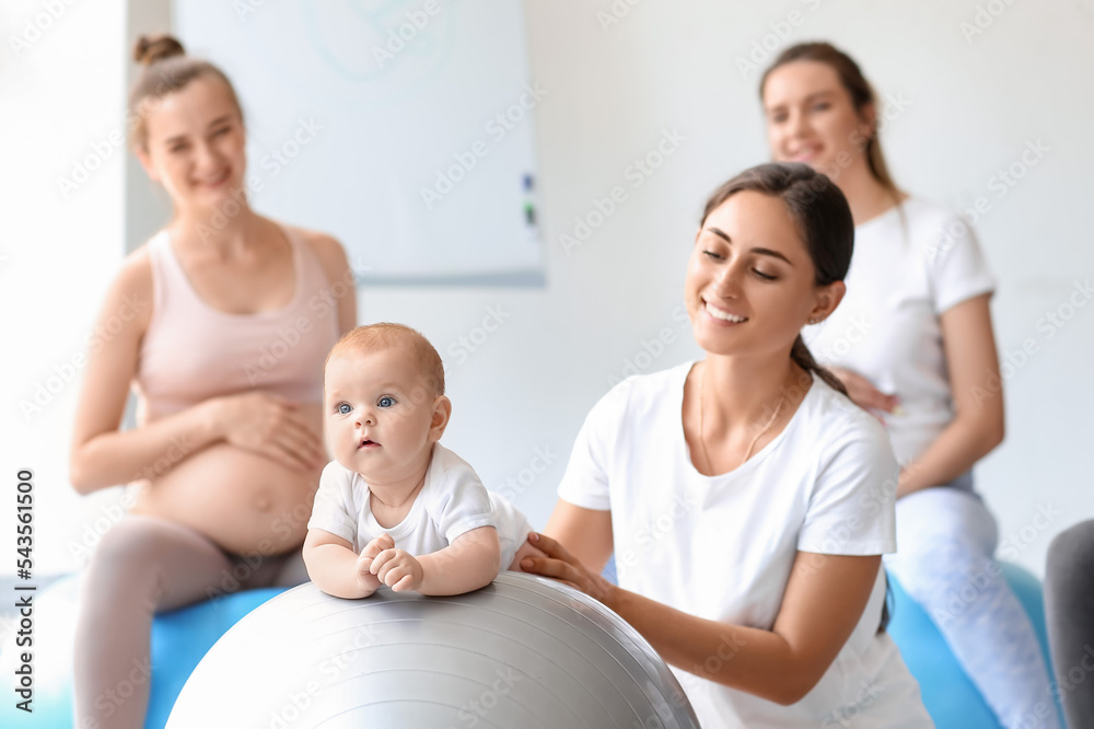 带着婴儿和孕妇在健身房训练的女教练