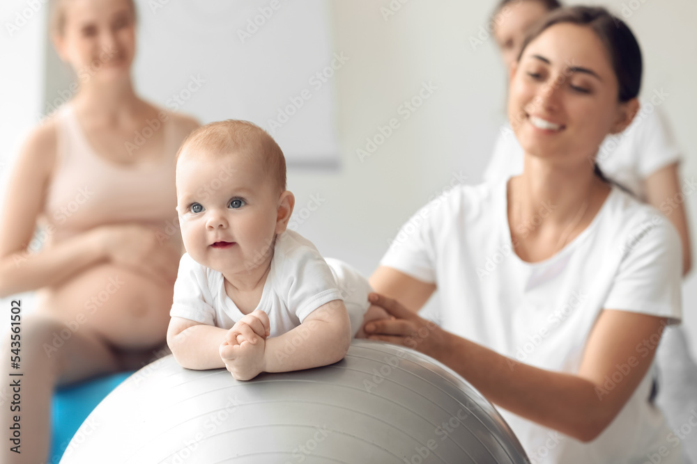 带着婴儿和孕妇的女教练在健身房训练