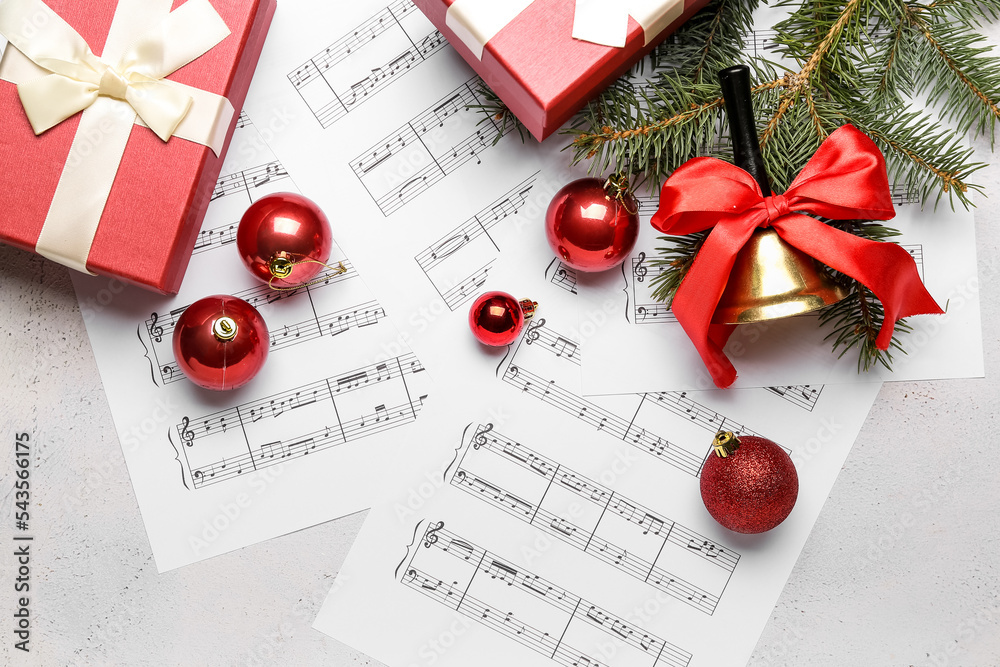 白色背景上有圣诞球、铃铛、冷杉树枝和礼物的纸条