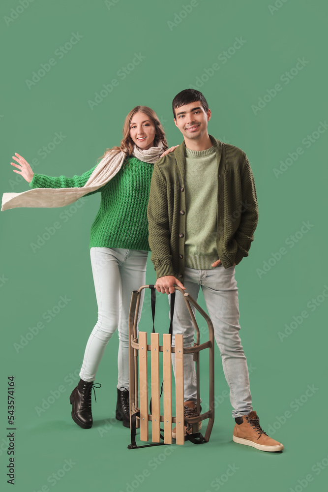 年轻情侣爱上绿色背景的行李箱