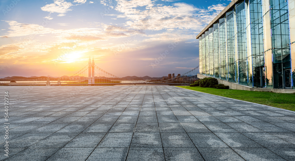 Empty square floor and bridge with urban skyline at sunset in Zhoushan, Zhejiang, China.