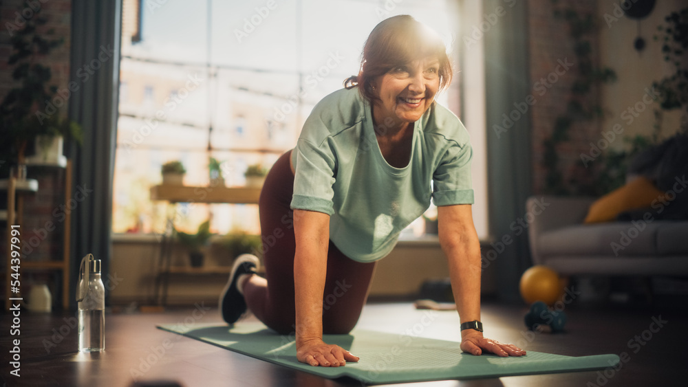 强健的老年女性在瑜伽垫上训练，做伸展和核心强化运动Du
