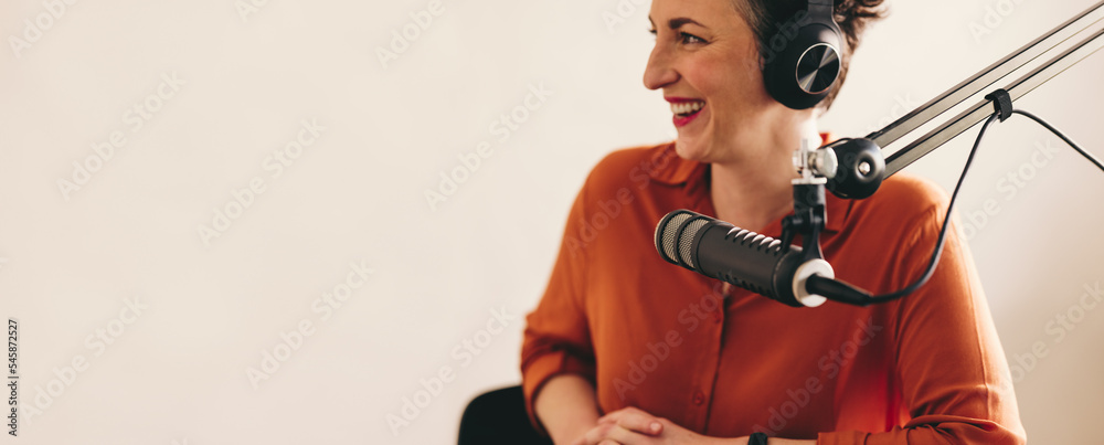 快乐的女人在她的广播节目中采访一位客人