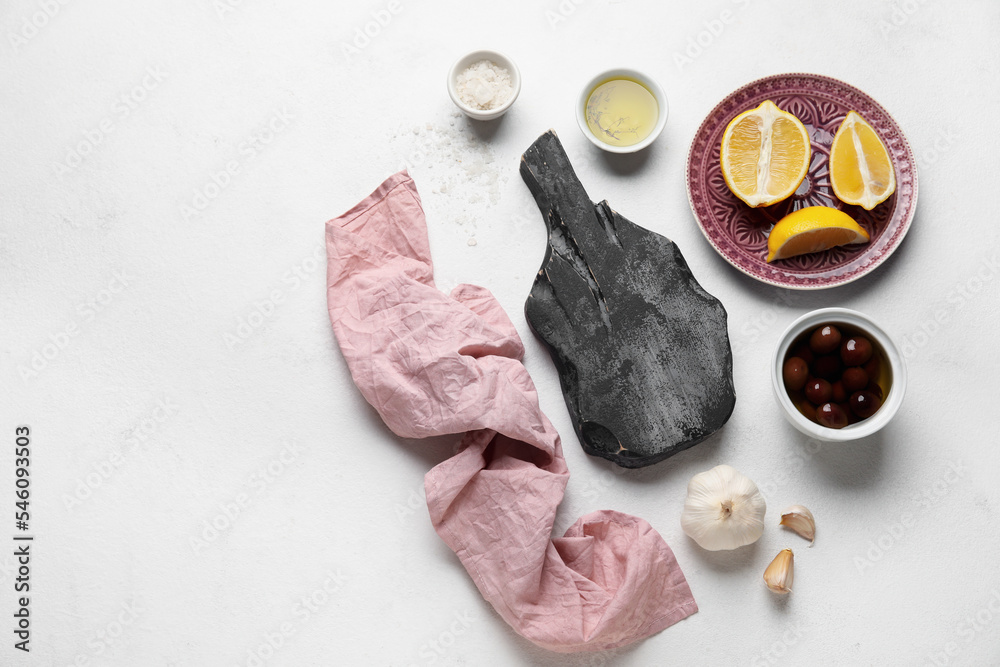 黑色木质砧板，白底餐巾、香料和柠檬