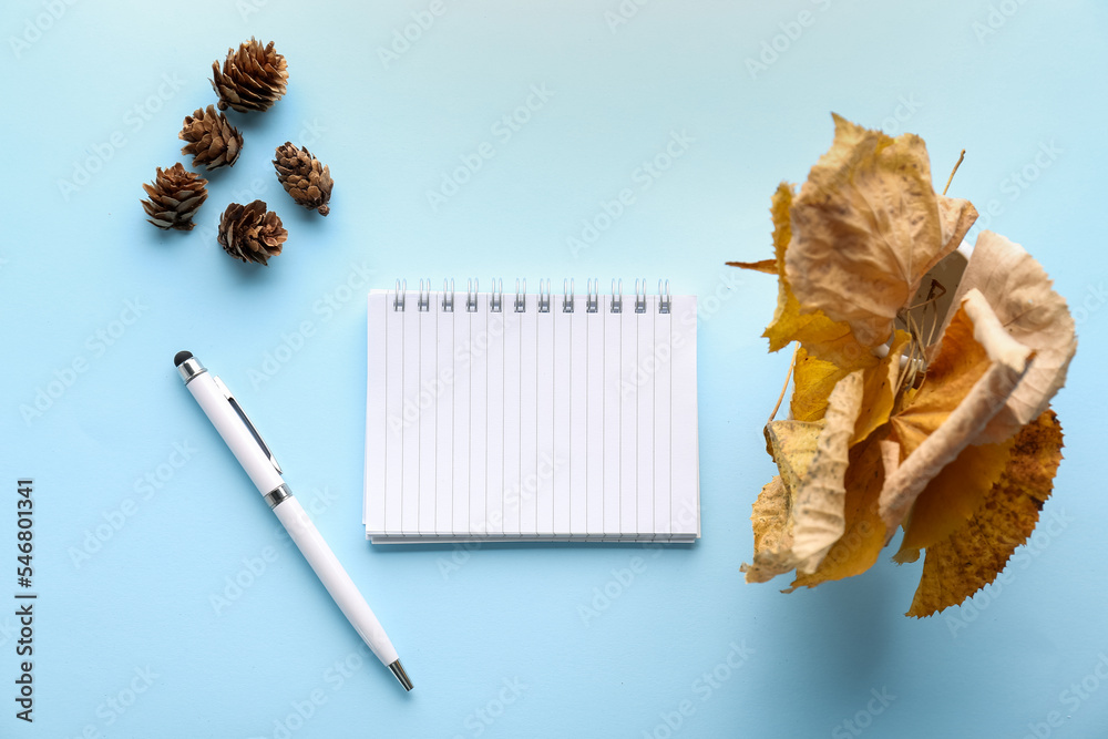 以空白笔记本、钢笔、秋叶和松果为背景的作文