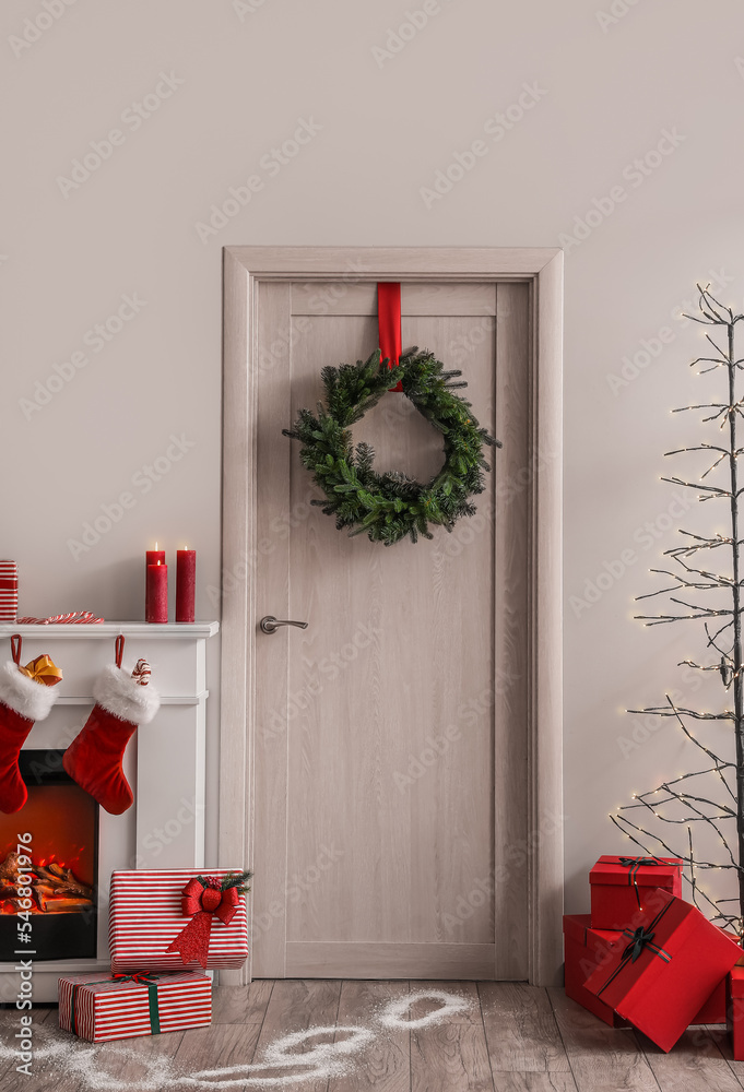 客厅里有圣诞花环、礼物和圣诞老人脚印的木门
