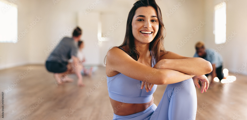 一位女士和她的班级坐在瑜伽馆里的肖像