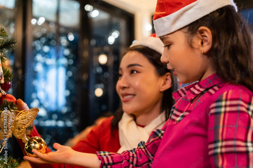高加索夫妇和年幼的女儿在家里装饰圣诞树。
