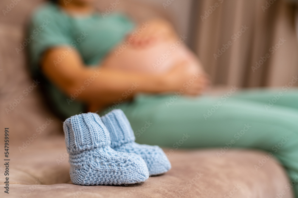 孕妇怀孕了。给未出生的婴儿穿小鞋。