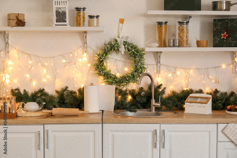 带圣诞花环、柜台和架子的厨房内部