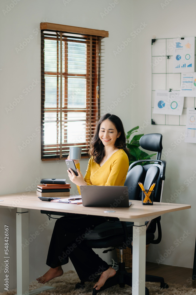 职场女性概念——一位女性经理参加视频会议，拿着平板电脑、smatrphone和