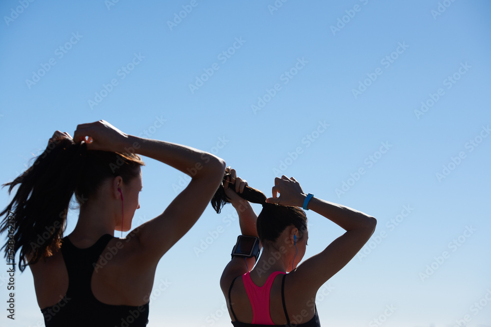 健身女性，跑步者在户外跑步后将头发绑在一起的剪影和蓝天背景，c