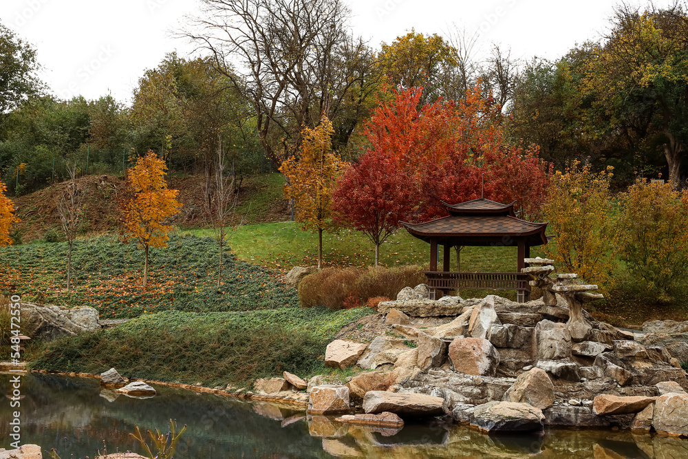 带凉亭、石头和池塘的秋季公园景观