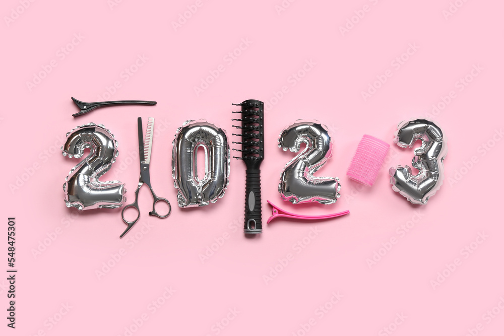 粉色背景下的气球和理发工具制成的图2023