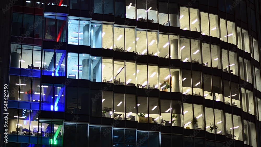 夜间城市中的现代办公楼。公司大楼照明办公室视图。Bl