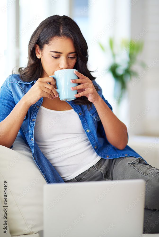女人、笔记本电脑，早上在沙发上喝咖啡放松，上网或阅读社交媒体