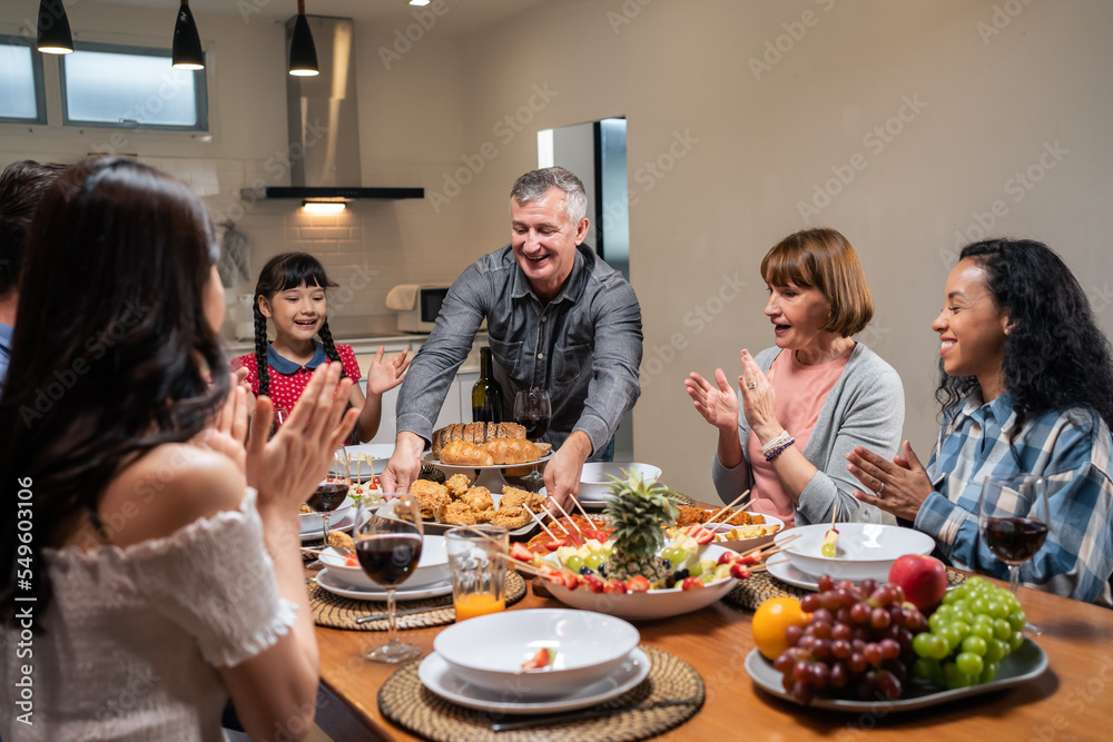 多民族大家庭共进晚餐，在家里享受晚会。
