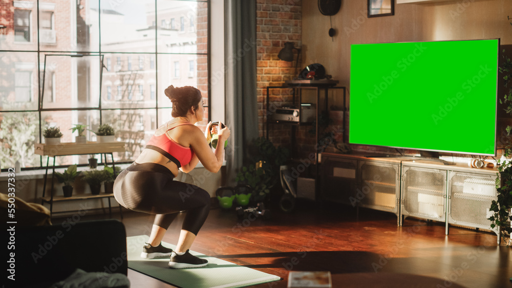 家庭健身房：华丽的大号身体积极女孩使用绿色模拟电视屏幕进行训练。Authent