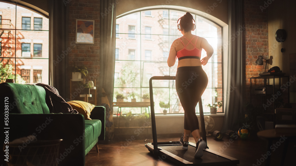 Beautiful Athletic Plus Size Body Positive Sports Woman Running on a Treadmill at Her Home Gym. Ener