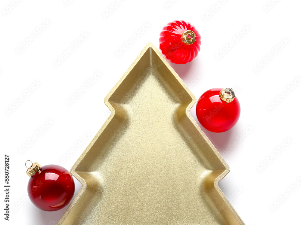 Plate in shape of Christmas tree and balls on white background, closeup