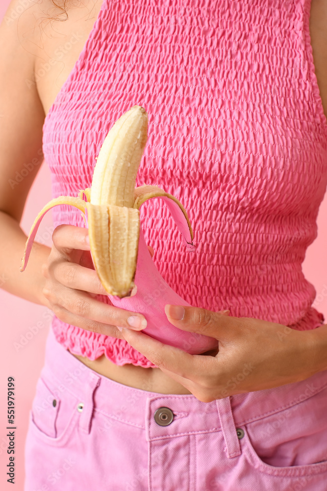 Woman holding peeled pink banana, closeup