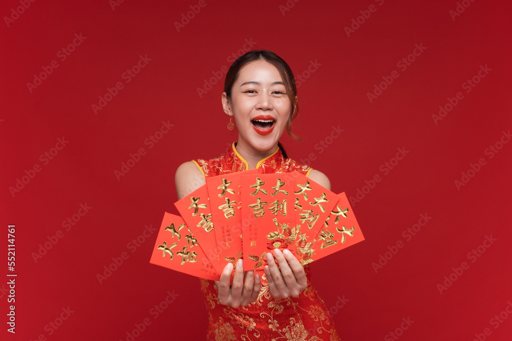 年轻的亚洲女性穿着红色背景的红色信封的中国新年奇装异服