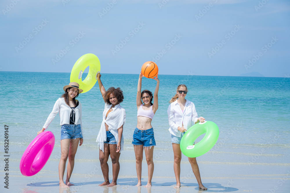 一群年轻女子在热带海滩上一起散步和玩耍，旅行和度假的好天气