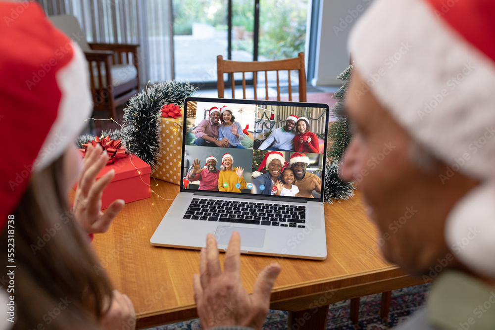 Caucasian father and daughter having christmas video call with diverse people