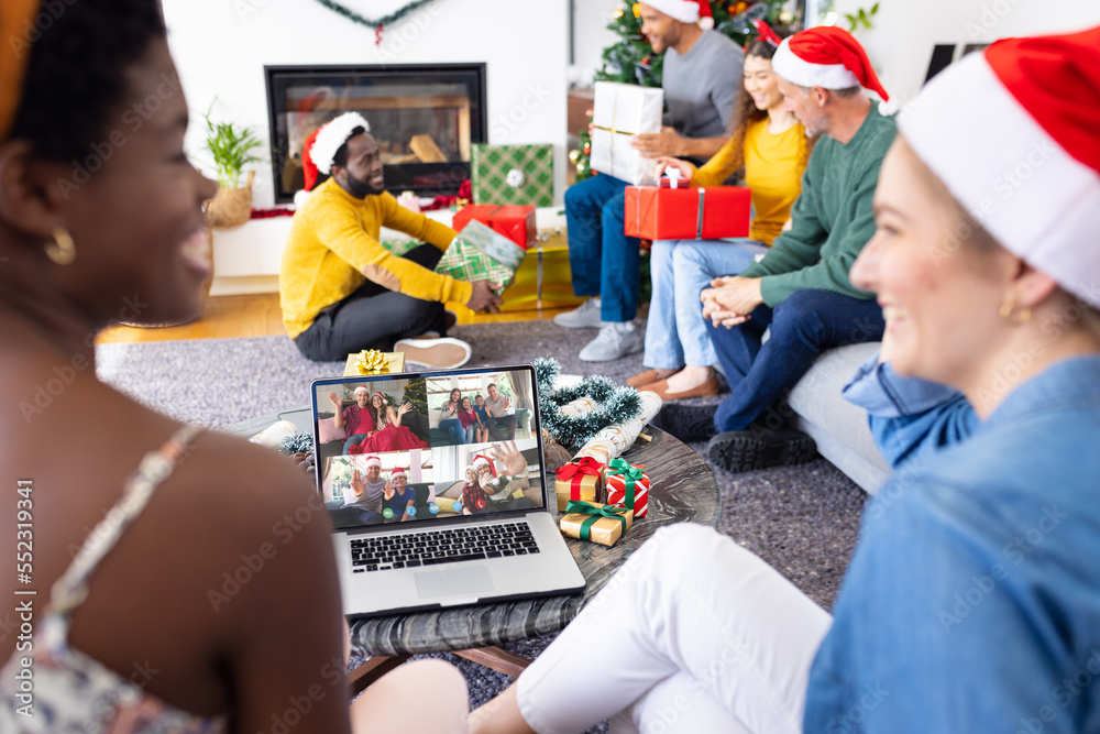 带着圣诞装饰品的多元化朋友与快乐的高加索朋友进行视频通话