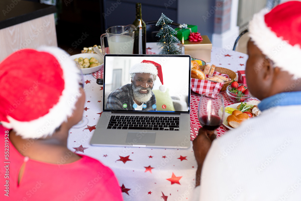 戴着圣诞老人帽的非裔美国夫妇与快乐的非裔美国人进行视频通话