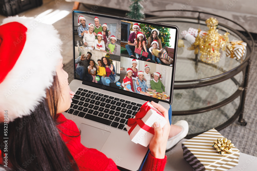 戴着圣诞老人帽的白人女性与快乐的不同朋友进行视频通话