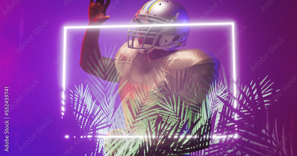 American football player wearing helmet raising hand by illuminated rectangle and plants