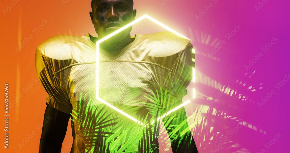 Portrait of american football player with face paint standing by illuminated plants and hexagon