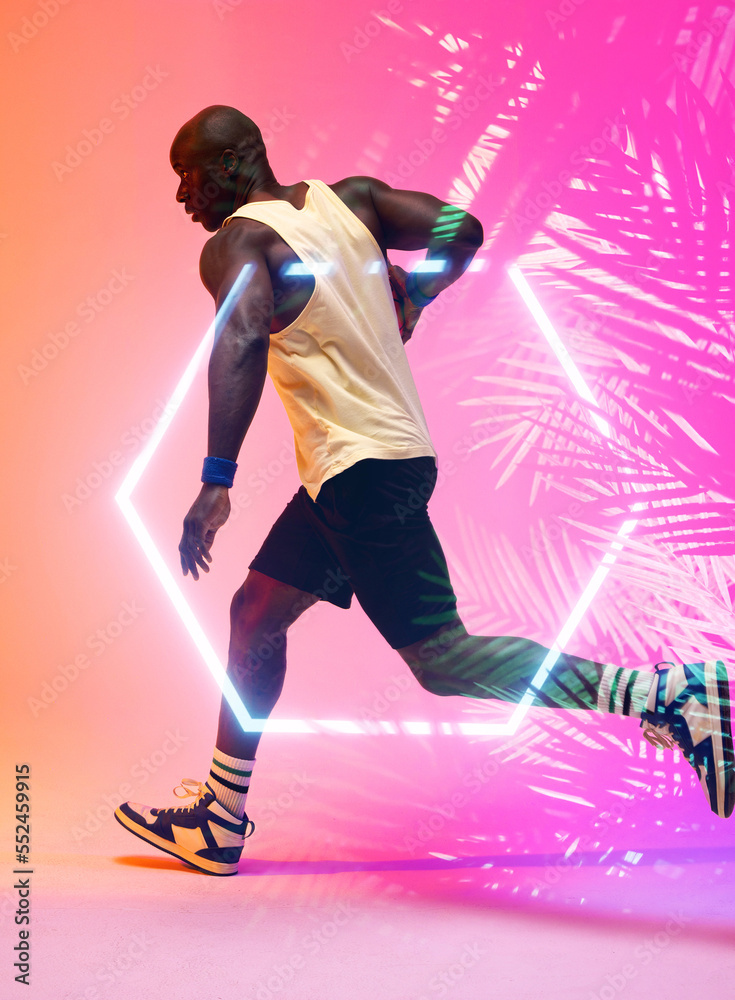 非裔美国篮球运动员用六边形和植物运球和跑动的侧视图
