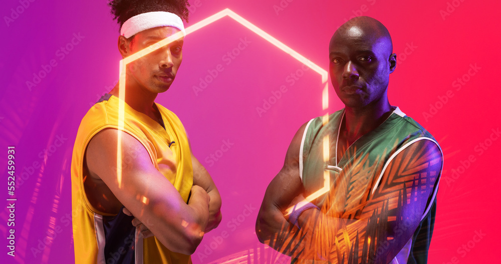 Serious african american basketball players with arms crossed by illuminated hexagon and plants