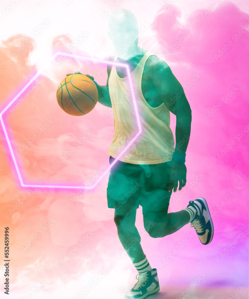African american male player dribbling basketball by illuminated hexagon on pink smoky background