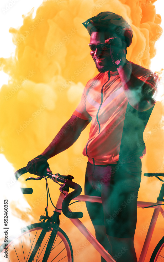African american male athlete wearing glasses and helmet while riding bike over smoky background