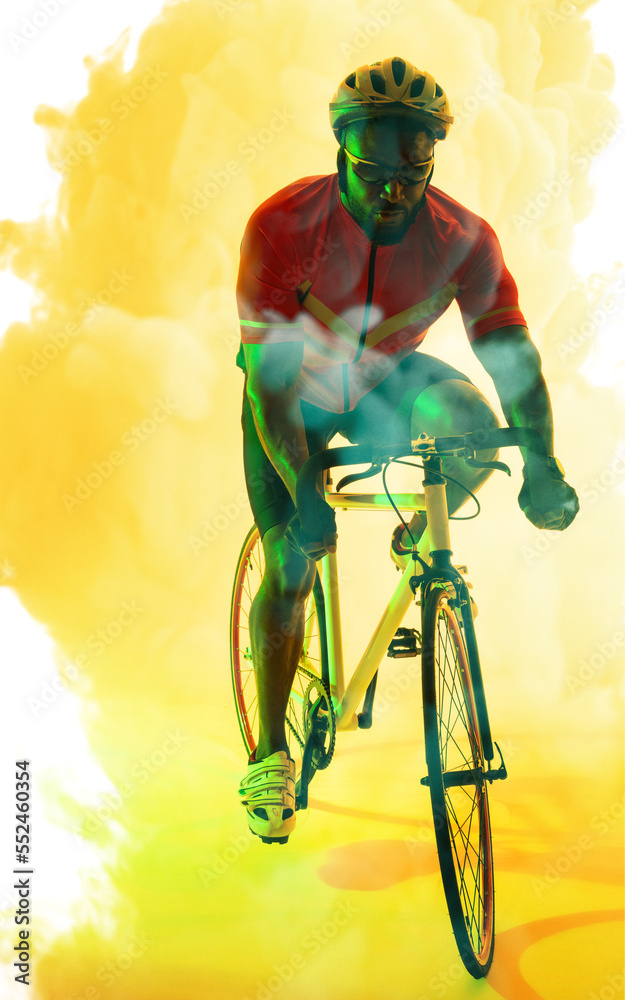 African american male athlete wearing helmet and glasses riding bike over smoky background