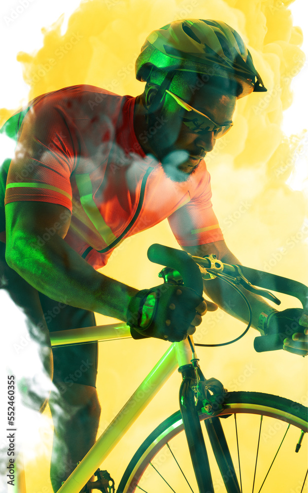 African american male cyclist wearing helmet and eyewear riding bike over yellow smoky background