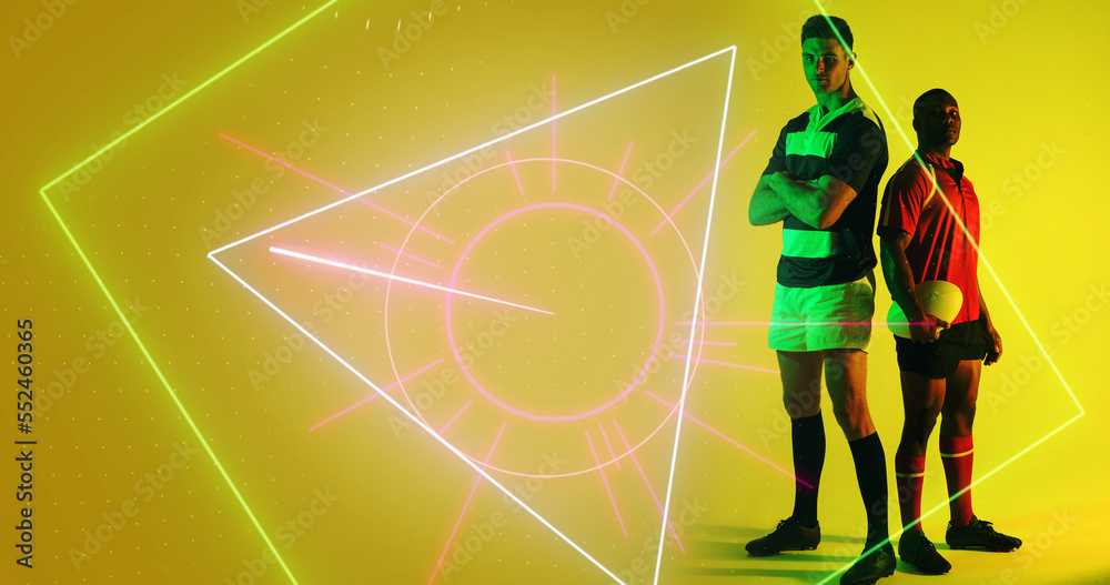 Composite of diverse male rugby players standing by illuminated geometric shape on yellow background