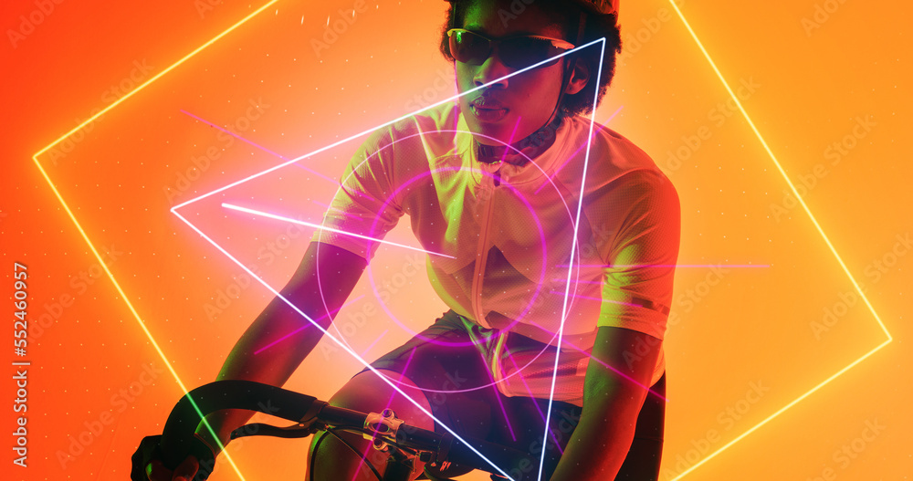 Biracial female athlete wearing glasses and helmet riding bike over illuminated geometric shapes