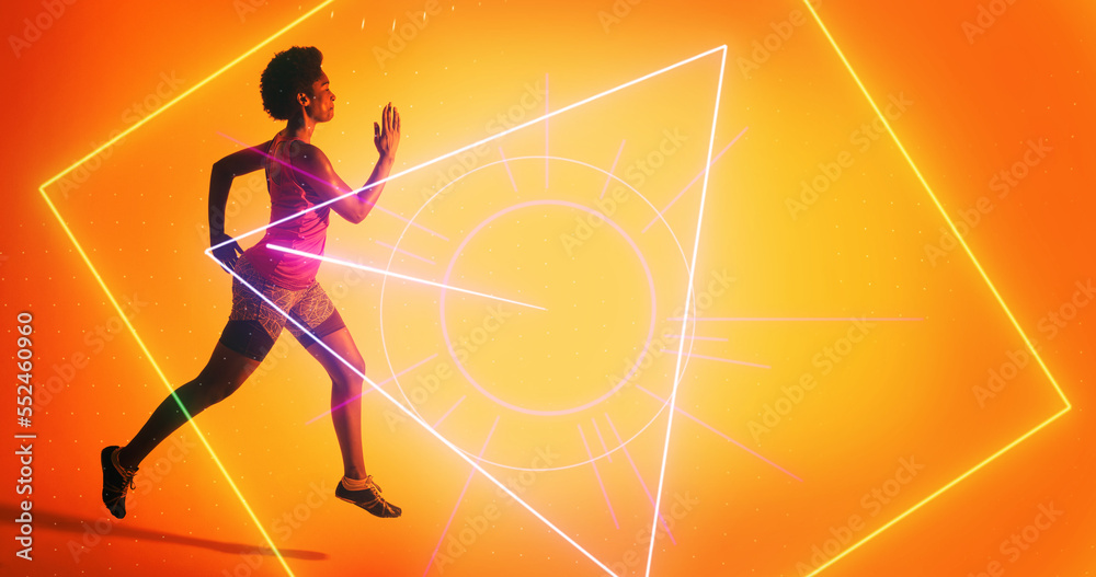 Side view of biracial female athlete running by illuminated geometric shapes on color background