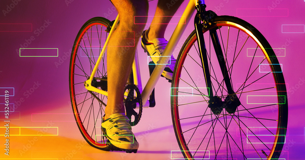 Low section of caucasian male athlete wearing shoes riding bike over rectangles on pink background
