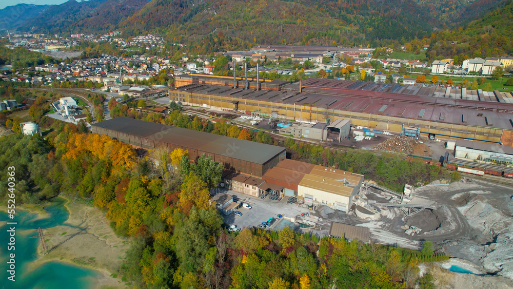 AERIAL: Industrial infrastructure near city and mountains in vibrant fall season
